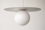 Lampa wisząca Robin D25 z białym kloszem w kształcie kuli zawieszona na cienkim przewodzie, z okrągłą, płaską podstawą. Prosta forma, minimalistyczny design, idealna do nowoczesnych wnętrz. Tło jasne, jednolite.