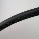 Lampa wisząca Apus w kolorze czarnym z 10 diodami LED. Zbliżenie na okrągły kształt klosza z widocznymi otworami na źródła światła. Powierzchnia matowa, elegancka, z subtelnym połyskiem. Tło jasne, co podkreśla detale lampy.
