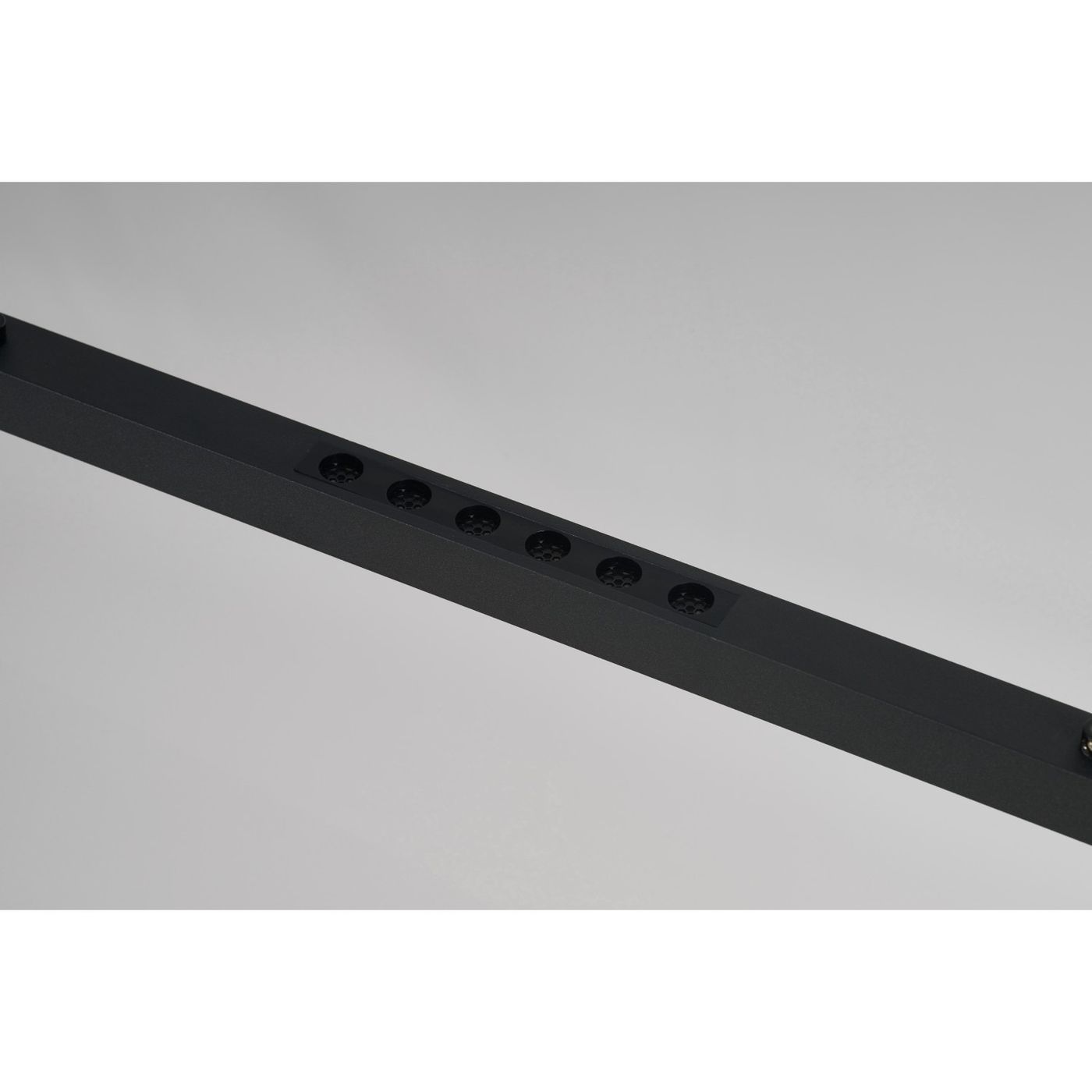 Lampa wisząca LED Fada 34W w kolorze czarnym, z prostokątnym metalowym korpusem. Z przodu widoczne sześć otworów na źródła światła, umieszczonych w równych odstępach. Produkt zawieszony, z minimalistycznym designem. Tło jasne.
