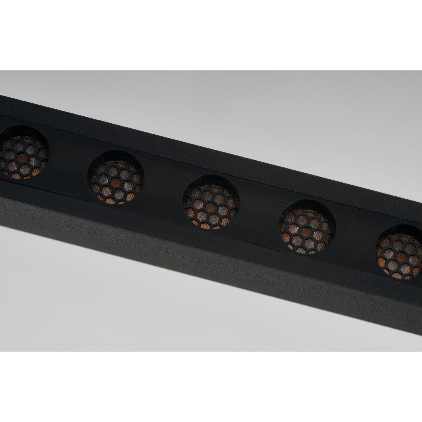 Czarna lampa wisząca LED Fada o mocy 34W, z metalową obudową i sześcioma okrągłymi otworami o strukturze plastra miodu, ukazującymi diody LED wewnętrzne. Ujęcie z boku, pokazujące detale wykonania i design.