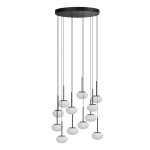 Lampa wisząca Serenity z 12 źródłami LED, moc 84W. Czarna konstrukcja z okrągłym, płaskim stropem i długimi, cienkimi przewodami. Białe, okrągłe klosze zawieszone na różnych wysokościach, tworzące nowoczesną aranżację świetlną.