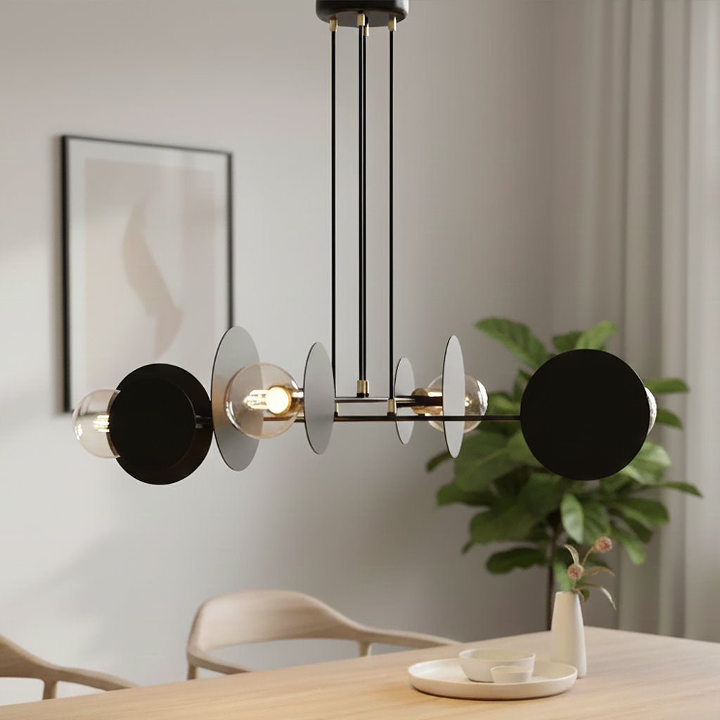 Czarna lampa wisząca 4-punktowa Idea 792/4 z okrągłymi, metalowymi elementami w dwóch kolorach, zawieszona na cienkich linkach. Widoczne żarówki w szklanych kloszach. Lampa w nowoczesnym wnętrzu, na tle rośliny doniczkowej i minimalistycznych mebli.