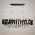 Lampa wisząca Cristal ML2518 z 10 gniazdami E14, w kolorze złotym i czarnym. Posiada ozdobne kryształy oraz elegancką, prostokątną formę. Ujęcie z przodu, zawieszona na złotej łańcuszku, na jasnym tle.