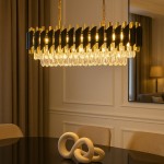 Lampa wisząca Cristal 10xE14 w złotym kolorze, z metalowymi elementami i kryształowymi zwisami. Ujęcie frontalne, zawieszona nad stołem w eleganckim wnętrzu, z widoczną dekoracją w kształcie węzła na stole. Tło w jasnych odcieniach.