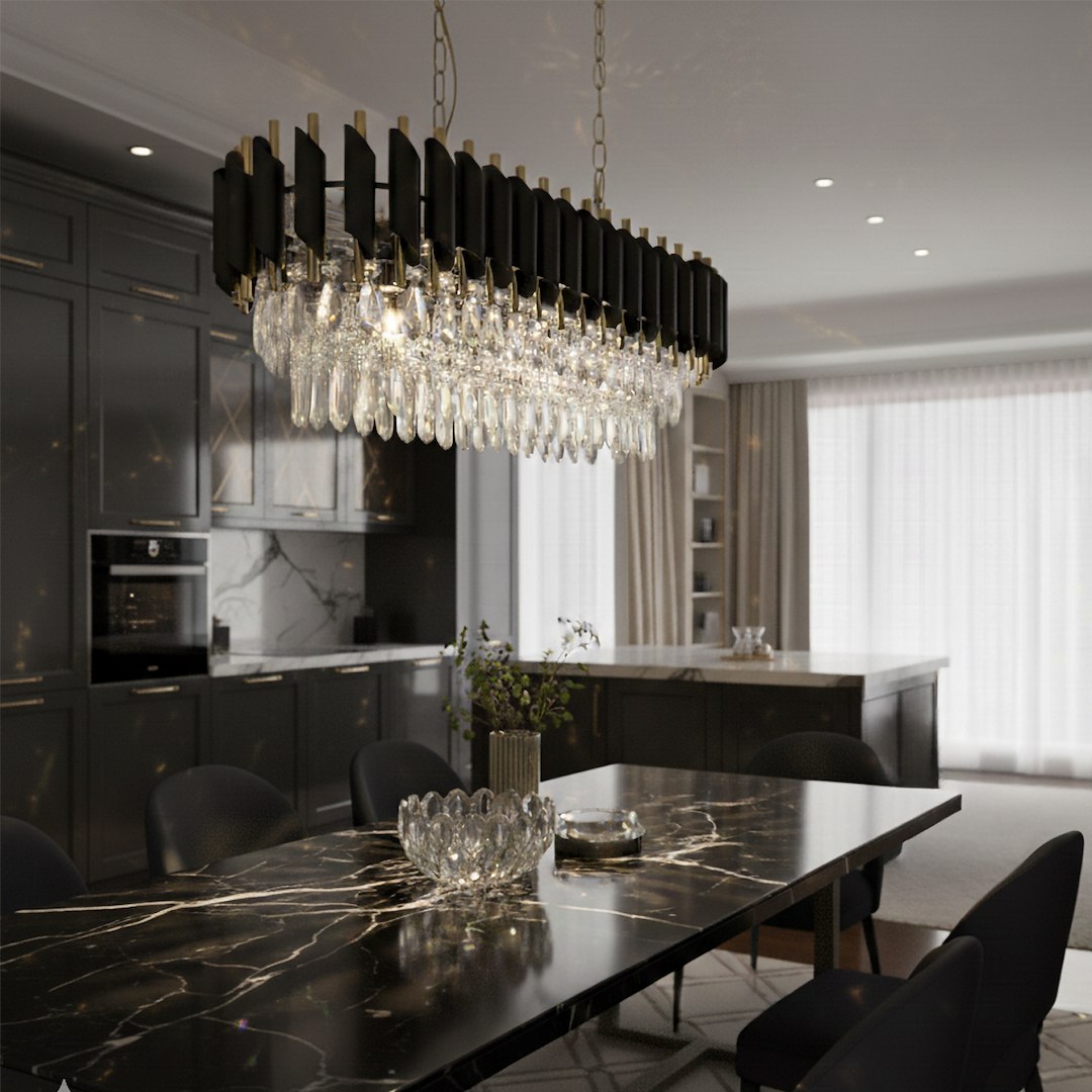 Lampa wisząca Cristal 10xE14 w kolorze złotym z kryształowymi elementami. Umieszczona nad czarnym stołem w nowoczesnej kuchni, z metalowymi detalami i eleganckim wykończeniem. Oświetlenie z efektem blasku, w otoczeniu ciemnych mebli i jasnych zasłon.