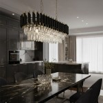 Lampa wisząca Cristal 10xE14 w kolorze złotym z kryształowymi elementami. Umieszczona nad czarnym stołem w nowoczesnej kuchni, z metalowymi detalami i eleganckim wykończeniem. Oświetlenie z efektem blasku, w otoczeniu ciemnych mebli i jasnych zasłon.