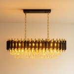 Lampa wisząca Cristal w złotym kolorze, z 10 gniazdami E14. Ozdobiona kryształowymi elementami, ma nowoczesny, falisty kształt. Zawieszona na złotej łańcuchowej konstrukcji, prezentuje się elegancko na jasnym tle.