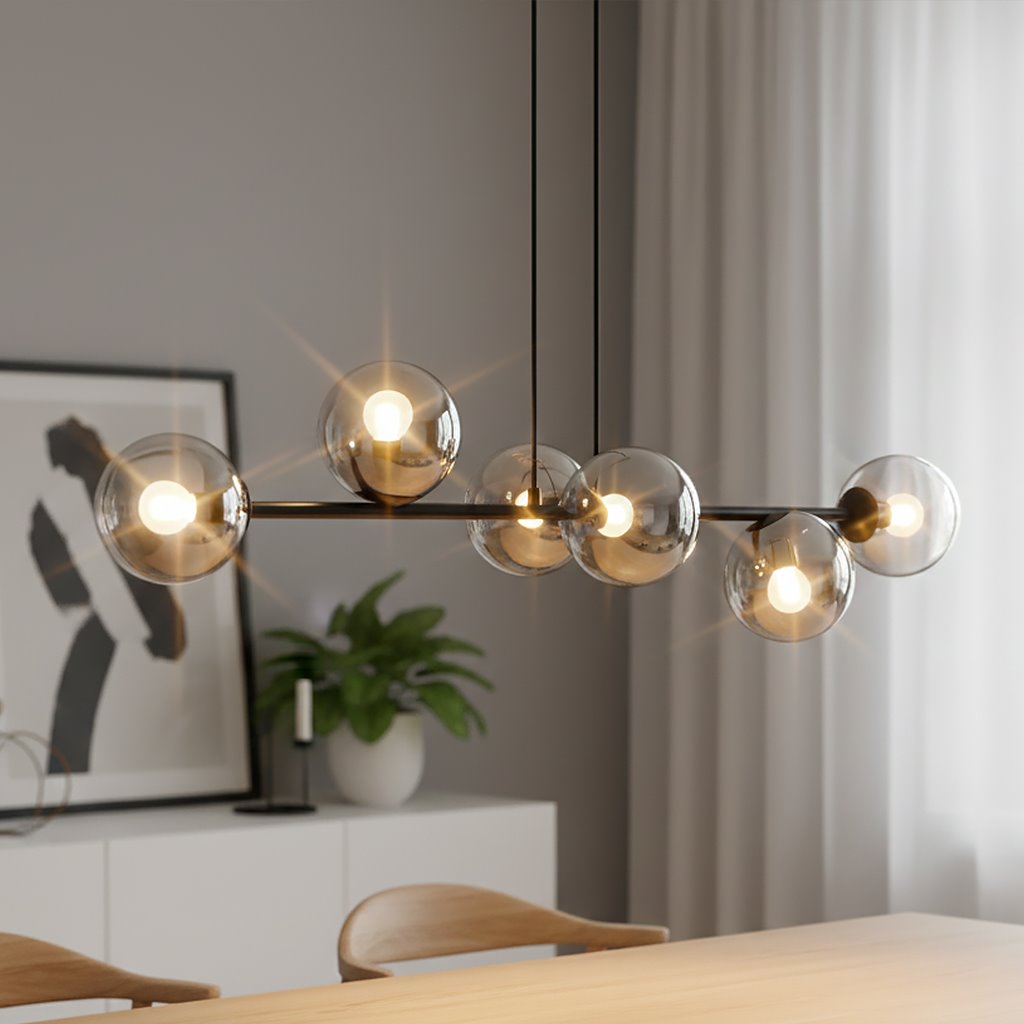 Lampa wisząca Rossi 6-punktowa w kolorze czarnym i grafitowym, z sześcioma przezroczystymi kulistymi kloszami, zawieszona na cienkich linkach. W tle widoczna roślinność oraz minimalistyczne meble w jasnym wnętrzu.