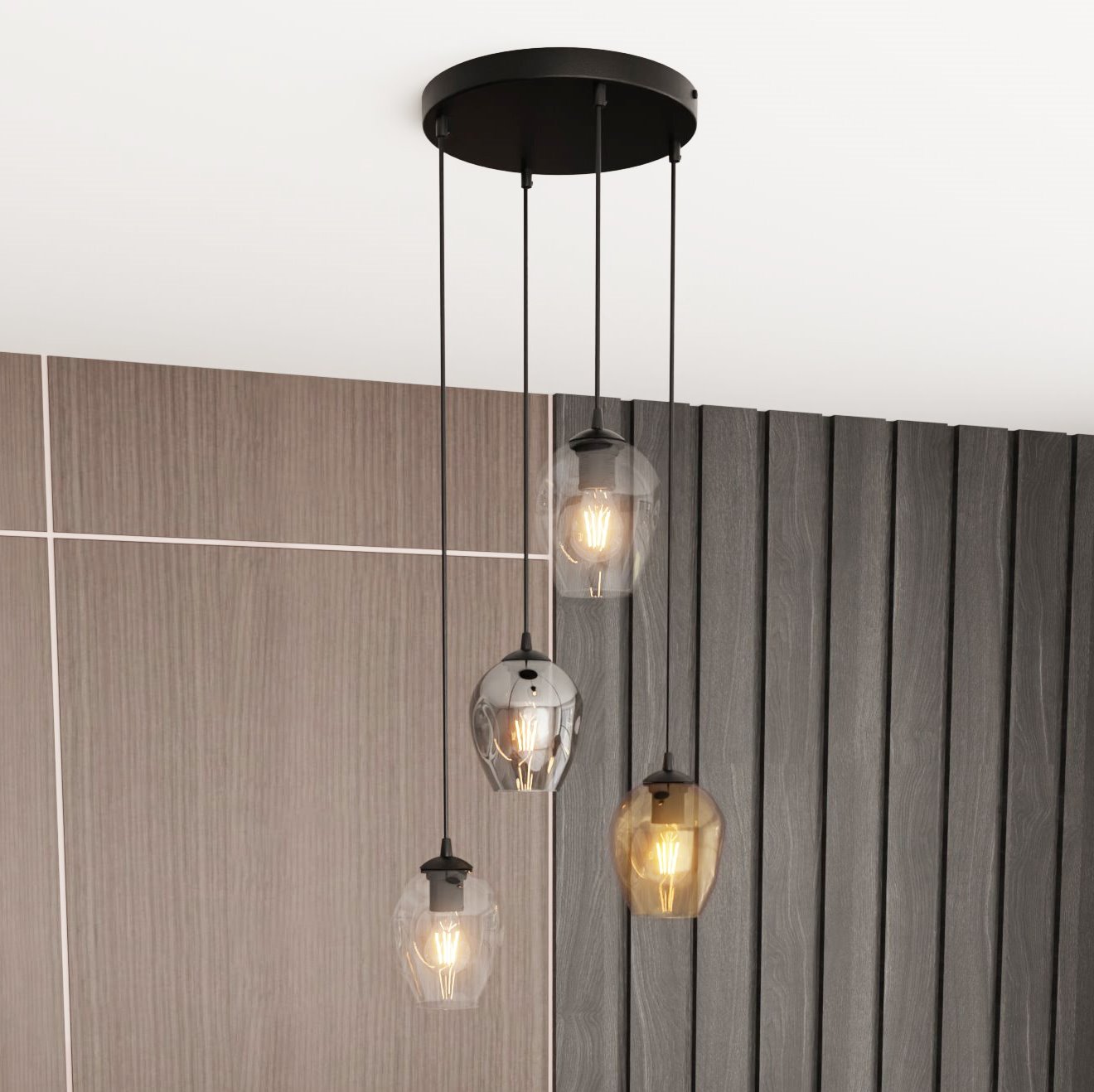 Lampa wisząca Istar Premium mix, 4-punktowa, z czarnym stelażem i czterema szklanymi kloszami w odcieniach przezroczystym, szarym i brązowym. Ujęcie z góry, zawieszona na długich przewodach, w tle drewniana ściana.