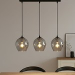 Lampa wisząca Istar 3-punktowa w kolorze grafitowym, z trzema szklanymi kloszami w kształcie łzy, zawieszona na cienkich linkach. W tle widoczny stół oraz minimalistyczne dekoracje.
