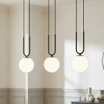 Czarna i biała lampa wisząca 3-punktowa Glam 1112/3 z okrągłymi, białymi kloszami zawieszonymi na długich, czarnych przewodach. Lampa umieszczona w jasnym wnętrzu, z widocznymi dekoracyjnymi elementami w tle.