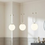Lampa wisząca Glam 3-punktowa w białym kolorze z okrągłymi kloszami. Zawieszona na białych przewodach z dekoracyjnymi złotymi detalami. Widok frontalny, umieszczona w jasnym wnętrzu z minimalistycznym wystrojem.