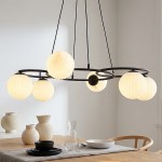 Lampa wisząca Libra z sześcioma opalowymi kulami na czarnej konstrukcji metalowej. Kule mają różne kształty i tekstury. Lampa zawieszona nad drewnianym stołem z białymi naczyniami i szklanym dzbankiem w jasnym wnętrzu.