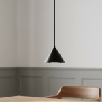 Lampa wisząca Elit 1xGX53 w kolorze czarnym, o stożkowym kształcie, zawieszona na cienkim przewodzie. Produkt umiejscowiony nad drewnianym stołem, w jasnym wnętrzu z szarymi ścianami. Minimalistyczny design podkreśla nowoczesny styl aranżacji.