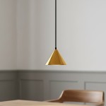 Lampa wisząca Elit 1xGX53 w kształcie stożka, czarna z metalicznym złotym wykończeniem. Zawieszona na cienkim czarnym przewodzie, umiejscowiona nad drewnianym stołem w jasnym wnętrzu.