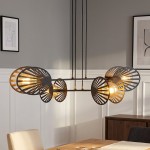 Czarna lampa wisząca Playa 4-punktowa z dekoracyjnymi, perforowanymi kloszami w kształcie liści. Zawieszona na długich, czarnych przewodach, idealna do nowoczesnych wnętrz. Tło jasnoszare, z elementami drewnianymi w aranżacji.