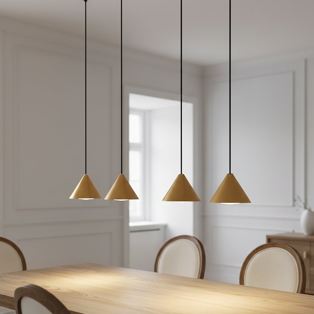 Lampa wisząca Elit 4xGX53 w kolorze czarnym i złotym, z czterema stożkowymi kloszami zawieszonymi na cienkich czarnych linkach. Produkt umieszczony nad drewnianym stołem w jasnym wnętrzu z niewielkimi meblami.