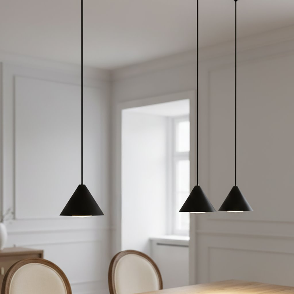 Czarna lampa wisząca Elit z trzema kloszami w kształcie stożków, zawieszona na długich kabelkach. Produkt znajduje się nad drewnianym stołem w jasnym wnętrzu z białymi ścianami. Klosze mają matowe wykończenie, co podkreśla ich minimalistyczny design.