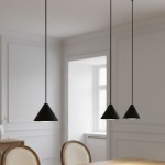 Czarna lampa wisząca Elit z trzema kloszami w kształcie stożków, zawieszona na długich kabelkach. Produkt znajduje się nad drewnianym stołem w jasnym wnętrzu z białymi ścianami. Klosze mają matowe wykończenie, co podkreśla ich minimalistyczny design.