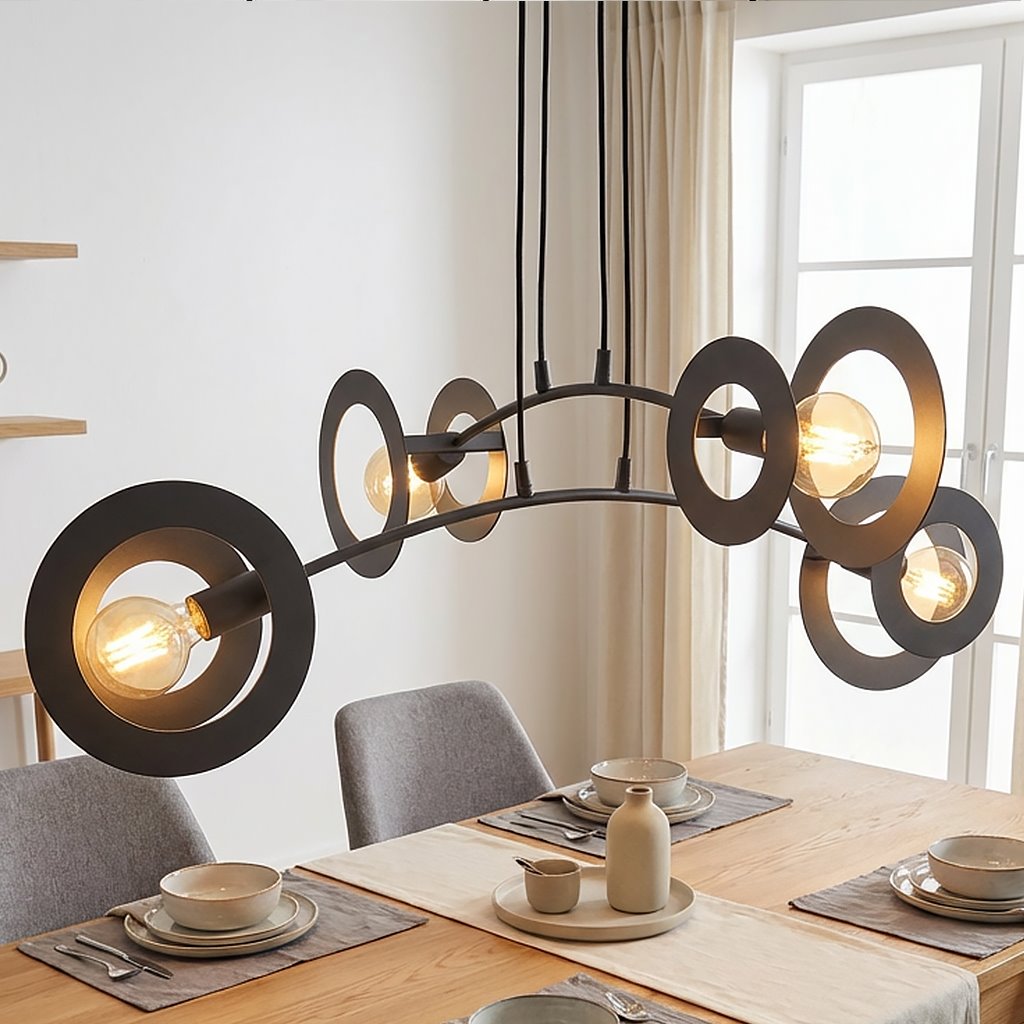Lampa wisząca Euforia, czarna, z czterema oprawami E27, o nowoczesnym designie z metalowymi okręgami. Zawieszona nad stołem, z widocznymi żarówkami, tworzy efektowne oświetlenie w aranżacji wnętrza.