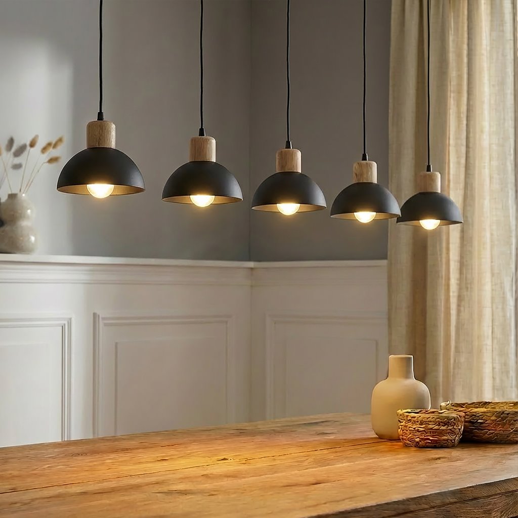 Lampa wisząca Seco z pięcioma kloszami E27 w kolorze czarnym z jasnym drewnem. Klosze mają półkolisty kształt, zawieszone na czarnych przewodach. Produkt umieszczony nad drewnianym stołem, w tle widoczna ściana z jasnymi panelami.