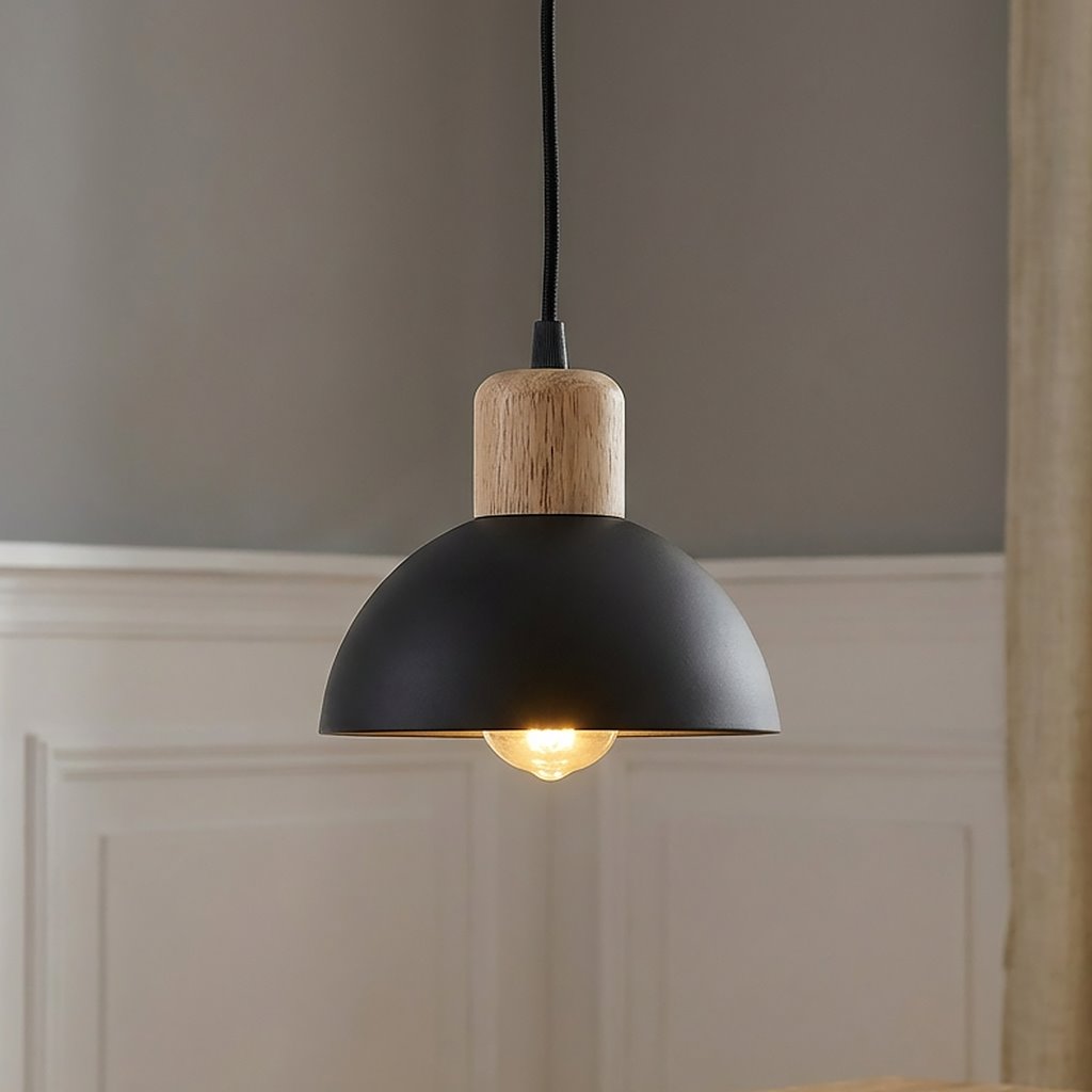 Lampa wisząca Seco z czarnym kloszem w kształcie półkuli i drewnianym uchwytem. Zawieszona na czarnym przewodzie, z widoczną żarówką E27. Tło w neutralnym kolorze, podkreślające elegancki design produktu.