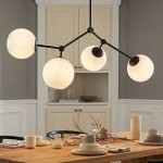 Czarna i biała lampa sufitowa 4-punktowa z kulistymi kloszami w odcieniu mlecznym, zawieszona nad drewnianym stołem. Lampa ma metalową konstrukcję w kształcie rozgałęzienia, zapewniającą równomierne oświetlenie w pomieszczeniu.