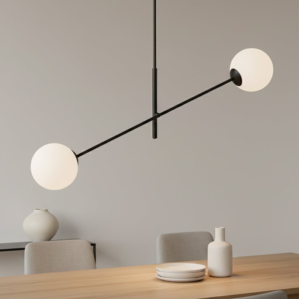 Lampa wisząca Linear 2-punktowa w kolorze czarnym i białym. Posiada dwa okrągłe klosze z białego szkła zawieszone na czarnej, cienkiej rurce. Ujęcie z boku, lampa wisząca nad drewnianym stołem, w tle neutralna ściana.