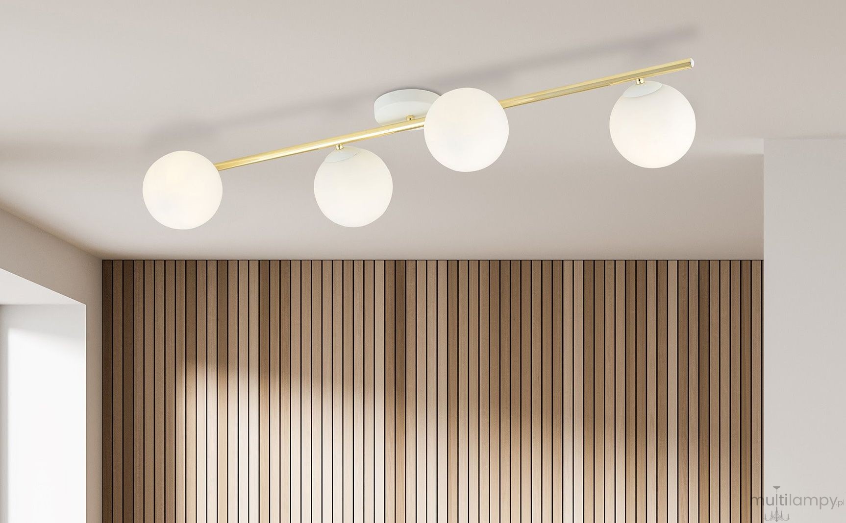 Lampa sufitowa 4-punktowa w kolorze białym i złotym z opalowymi kloszami. Ułożona równolegle, z czterema okrągłymi kloszami, mocowana do sufitu. Tło w jasnym kolorze z drewnianą, pionową fakturą.
