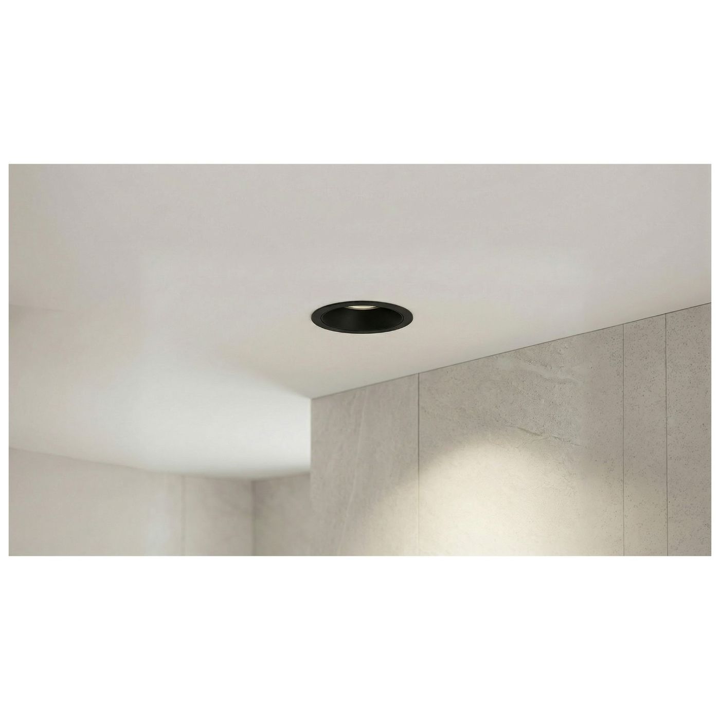 Oprawa sufitowa LED Mirt 15W w kolorze czarnym, wbudowana w sufit. Widok z boku, pokazujący okrągły kształt i gładką, matową powierzchnię. Otoczenie z jasnym tłem i teksturowaną ścianą w odcieniu szaro-beżowym.