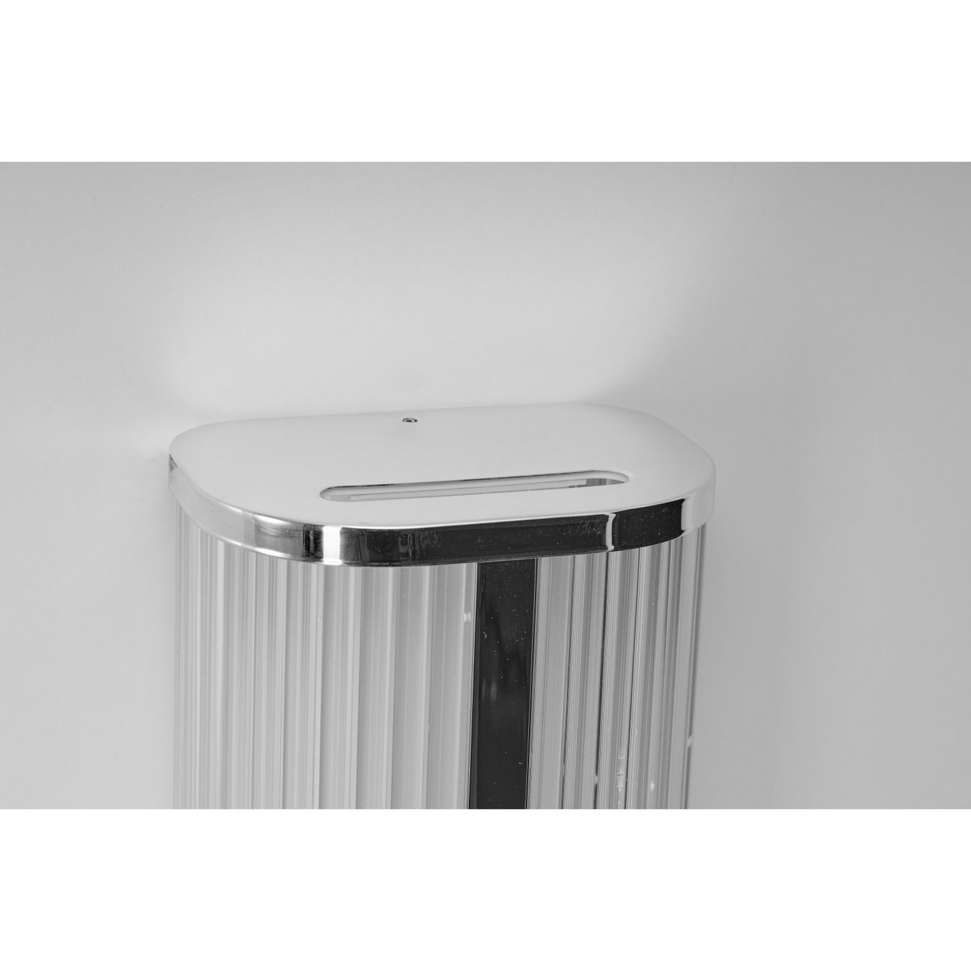 Kinkiet LED Pandora 11W CCT IP44 w kolorze chromu, z prostokątnym, gładkim uchwytem i teksturowanym kloszem z przezroczystego materiału. Zamontowany na ścianie, w widoku z góry, ukazujący detal górnej części.