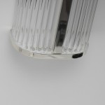 Kinkiet LED Pandora 11W CCT IP44 w chromowanej obudowie. Z zaokrąglonym, przezroczystym kloszem z pionowymi żłobieniami. Ujęcie z boku, ukazujące detale wykończenia i materiałów. Umożliwia oświetlenie w pomieszczeniach o podwyższonej wilgotności.