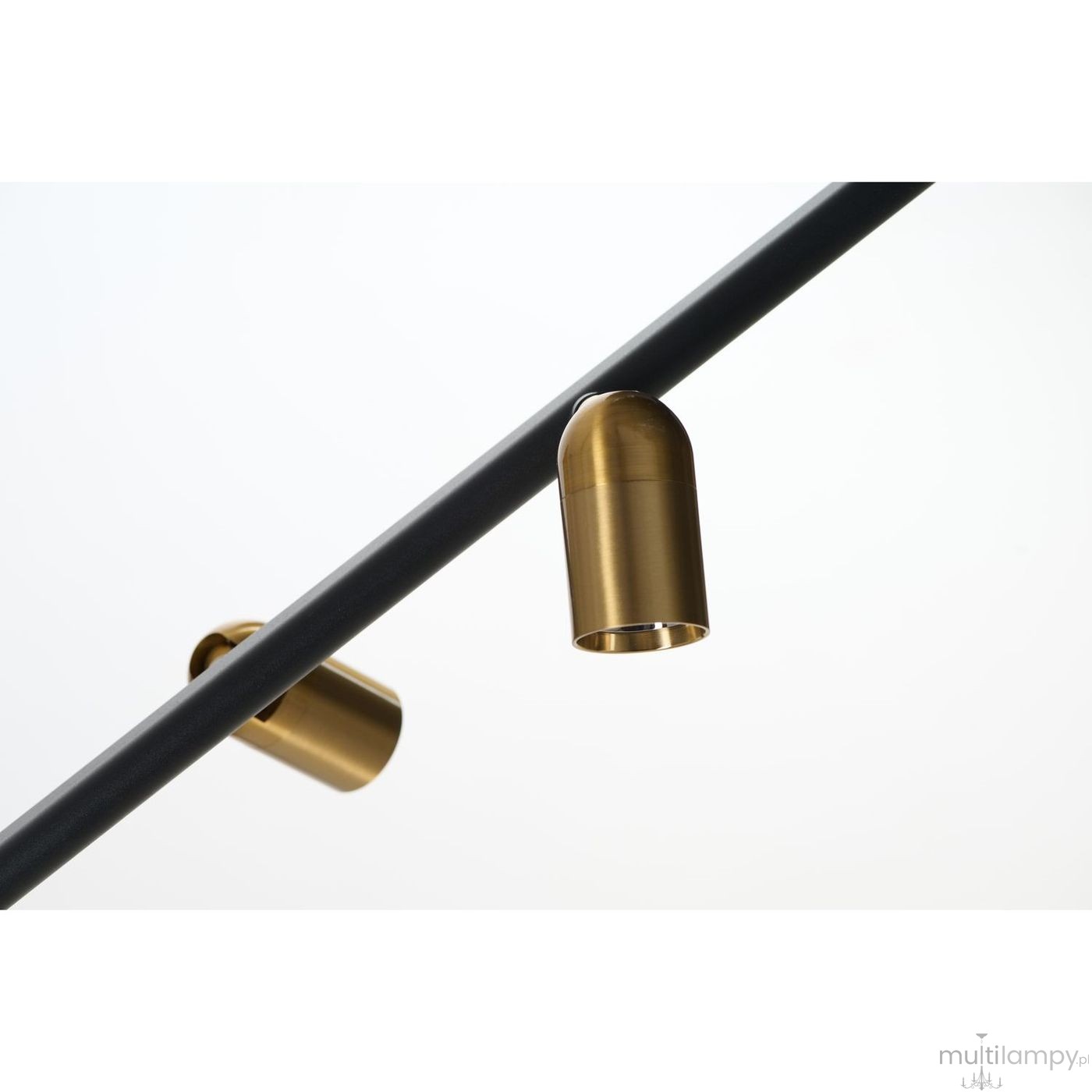 Lampa wisząca Trasimeno w kolorze czarnym z dwoma źródłami światła LED 10W i dwoma gniazdami G9. Widok zbliżeniowy na złote oprawy lamp, umieszczone na czarnym stelażu. Prosty, nowoczesny design.