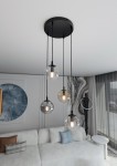 Lampa wisząca Cosmo Premium 4-punktowa w różnych kolorach, z czterema szklanymi kloszami w kształcie kul, zawieszona na czarnych przewodach, montowana na okrągłej podstawie. Widoczna w nowoczesnym wnętrzu z jasną kanapą.