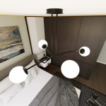 Czarna lampa wisząca Halldor 4-punktowa z czterema okrągłymi, białymi kloszami, umieszczona na czarnym stelażu, zawieszona w sypialni nad łóżkiem z szarym narzutą. Tło z ciemnego drewna i obrazem w odcieniach niebieskiego.