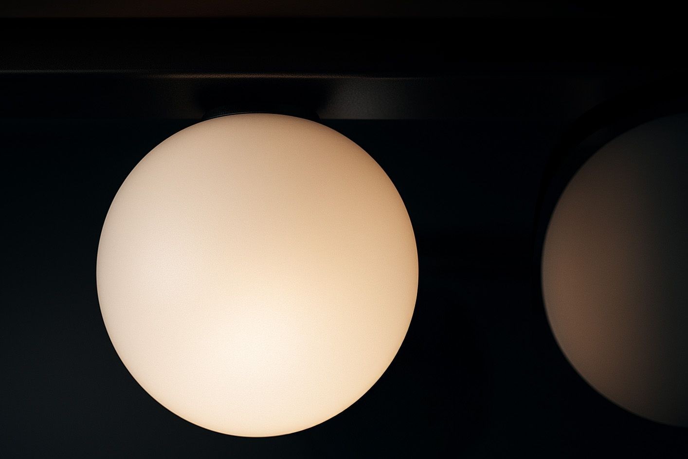 Lampa sufitowa Swing w kolorze czarnym z 4 gniazdami GU10 i 2 gniazdami G9. Okrągłe, matowe klosze w białym kolorze, umieszczone na prostokątnej podstawie. Widok z boku, ukazujący detale kloszy i ich rozmieszczenie.