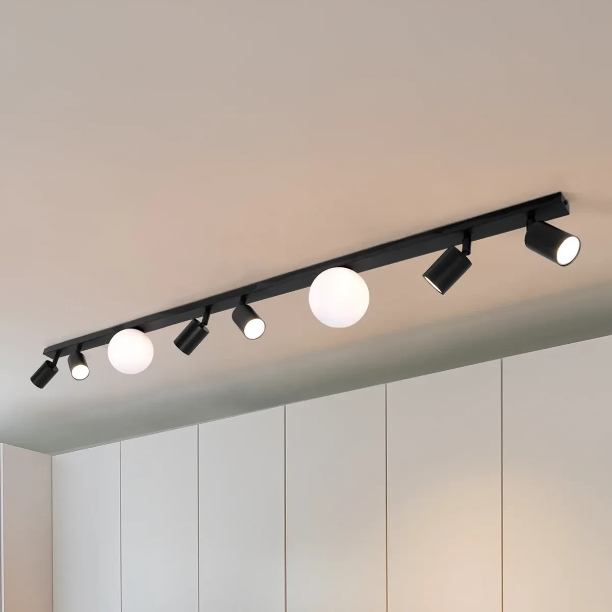 Lampa sufitowa Swing w kolorze czarnym, z sześcioma reflektorami GU10 i dwiema kulami G9. Ujęcie z góry, zamontowana na suficie, z nowoczesnym designem i różnymi kształtami lamp. Widoczne białe i czarne detale.