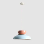 Lampa wisząca Aldo w kolorze błękitnym i koralowym, z metalowym kloszem w kształcie miski. Produkt zawieszony na cienkim przewodzie, z okrągłym mocowaniem sufitowym w białym kolorze. Idealna do nowoczesnych wnętrz.
