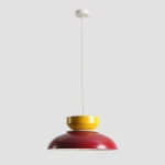 Lampa wisząca Aldo z jednym gniazdem E27 w kolorze czerwonym wina i musztardowym. Produkt zawieszony na białym przewodzie, z okrągłym, płaskim mocowaniem sufitowym. Kształt harmonijnie łączy dwa odcienie, tworząc nowoczesny akcent do wnętrza.