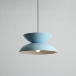 Lampa wisząca Millo w kolorze błękitnym, składająca się z dwóch połączonych części w kształcie misek. Utrzymana na czarnym przewodzie, z widoczną żarówką E27 w dolnej części. Tło jasnoszare, minimalistyczne.