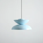 Lampa wisząca Millo w kolorze błękitnym, z dwoma półkulistymi kloszami, zawieszona na cienkim czarnym kablu. Górny klosz ma kształt płaskiej miski, dolny jest zaokrąglony, co tworzy nowoczesny wygląd. Tło jednolite, jasne.
