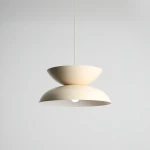 Lampa wisząca Millo w kolorze jasnego kremu, o nowoczesnym designie z dwoma półkulami, zawieszona na cienkim przewodzie. Dolna część lampy jest lekko wypukła, a środek jest otwarty, co eksponuje źródło światła.