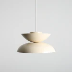 Lampa wisząca Millo w kolorze jasnej kremowej, składająca się z dwóch połączonych elementów w kształcie misek, zawieszona na cienkim przewodzie. Produkt wykonany z matowego materiału, z widocznym gwintem E27.