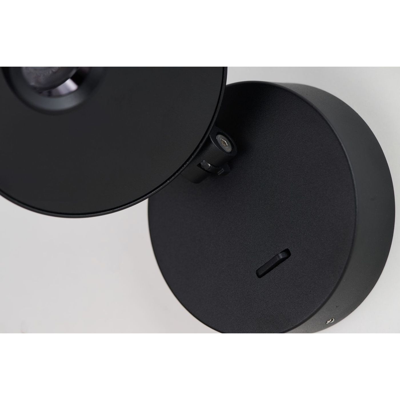 Kinkiet spot LED Iseo 3W w kolorze czarnym, zamontowany na ścianie. Okrągła podstawa z matowego metalu oraz regulowana czasza, która kieruje światło w pożądanym kierunku. Prosty, nowoczesny design, idealny do różnych aranżacji wnętrz.
