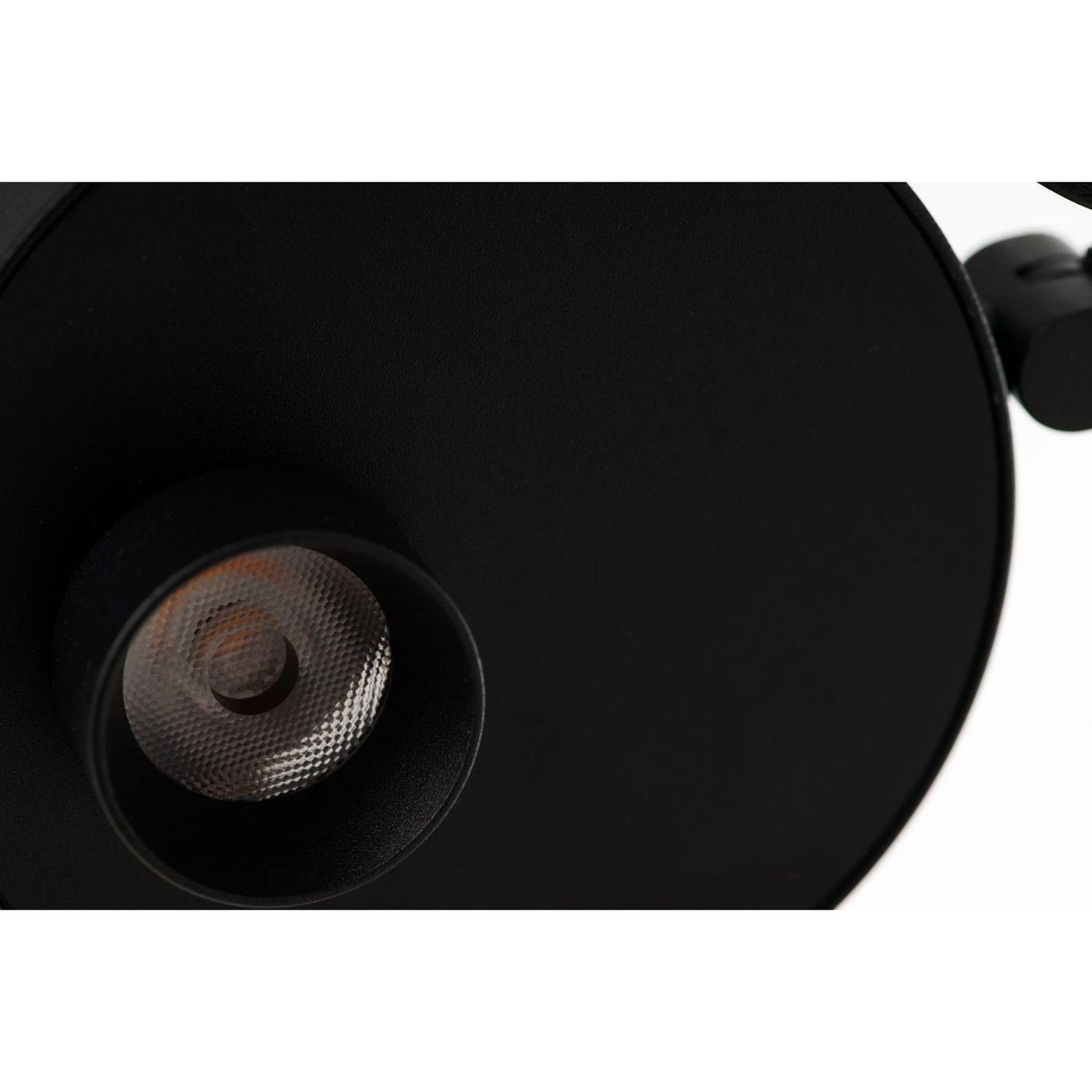 Czarna lampa wisząca LED Iseo 7W, z okrągłym kloszem i metalową podstawą. Zbliżenie na źródło światła z siatkowym wykończeniem, umieszczone w centralnej części lampy. Prosta, nowoczesna forma, odpowiednia do różnych aranżacji wnętrz.
