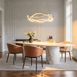 Lampa wisząca LED 36W CCT w kolorze złotym, o nowoczesnym, falistym kształcie, zawieszona nad okrągłym stołem w eleganckim wnętrzu. Otoczenie z jasnymi ścianami, marmurowym blatem i stylowymi krzesłami w odcieniu brązu.