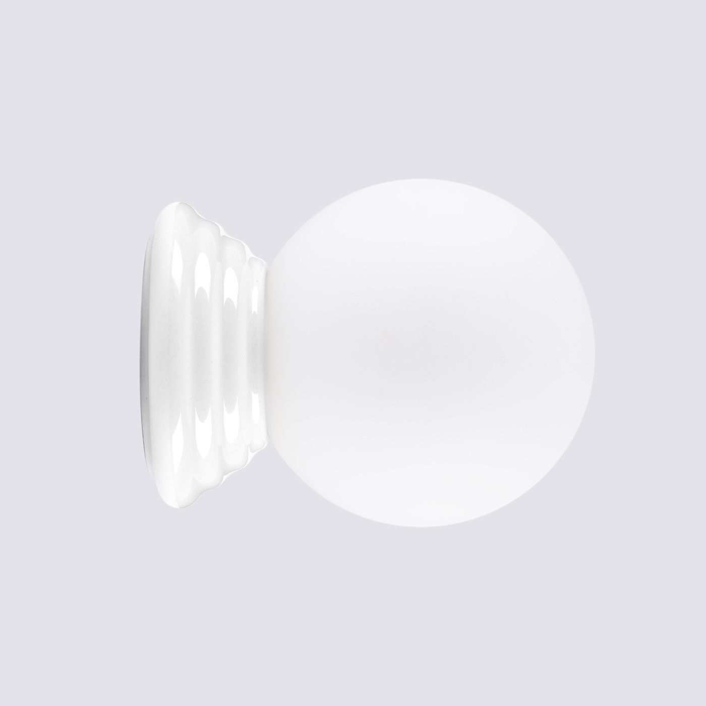 Biały kinkiet Zori 1xG9 IP44 z okrągłym kloszem i falistym mocowaniem. Widok frontalny, produkt zamontowany na ścianie, wykonany z materiałów odpornych na wilgoć. Idealny do łazienek i przestrzeni zewnętrznych.