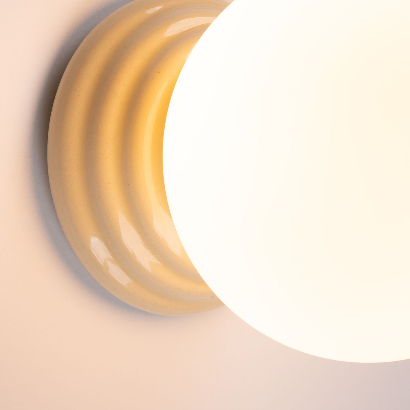 Beżowy kinkiet Zori 1xG9 IP44 z okrągłą, matową oprawą i falistą podstawą. Produkt widoczny z góry, ukazujący detale kształtu i struktury. Idealny do wnętrz oraz na zewnątrz, odporny na wilgoć.