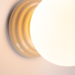 Beżowy kinkiet Zori 1xG9 IP44 z okrągłą, matową oprawą i falistą podstawą. Produkt widoczny z góry, ukazujący detale kształtu i struktury. Idealny do wnętrz oraz na zewnątrz, odporny na wilgoć.