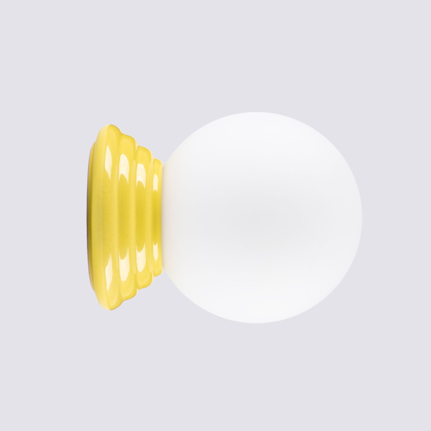 Kinkiet Zori 1xG9 IP44 w kolorze żółtym, z okrągłą białą kloszem i żółtą, teksturowaną podstawą w kształcie stożka. Produkt prezentowany frontalnie na jednolitym tle.